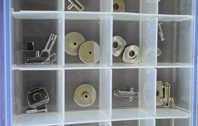 mim-components-overview A sample tray of MIM-produced components: gears, levers, connectors, and precision mechanisms in stainless steel and specialty alloys